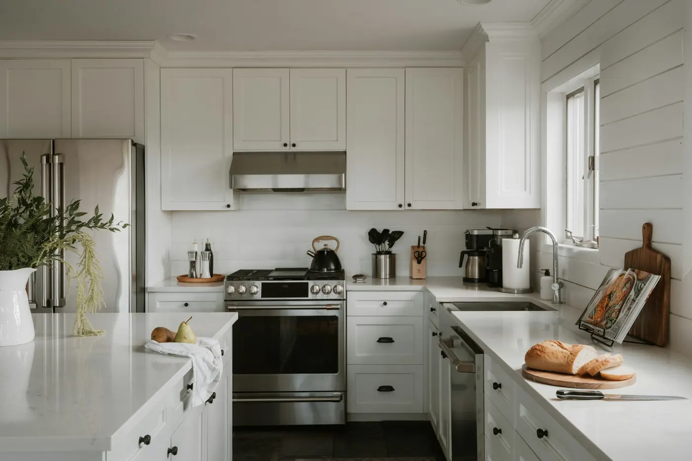 Clean white kitchen with stainless steel appliances
