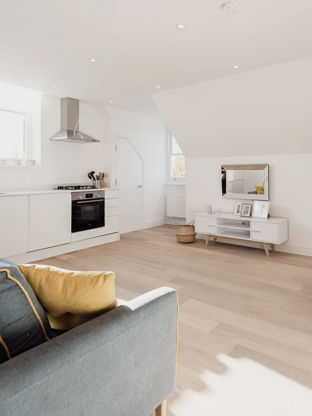 Bright, tidy living room with a gray sofa and light wood floors