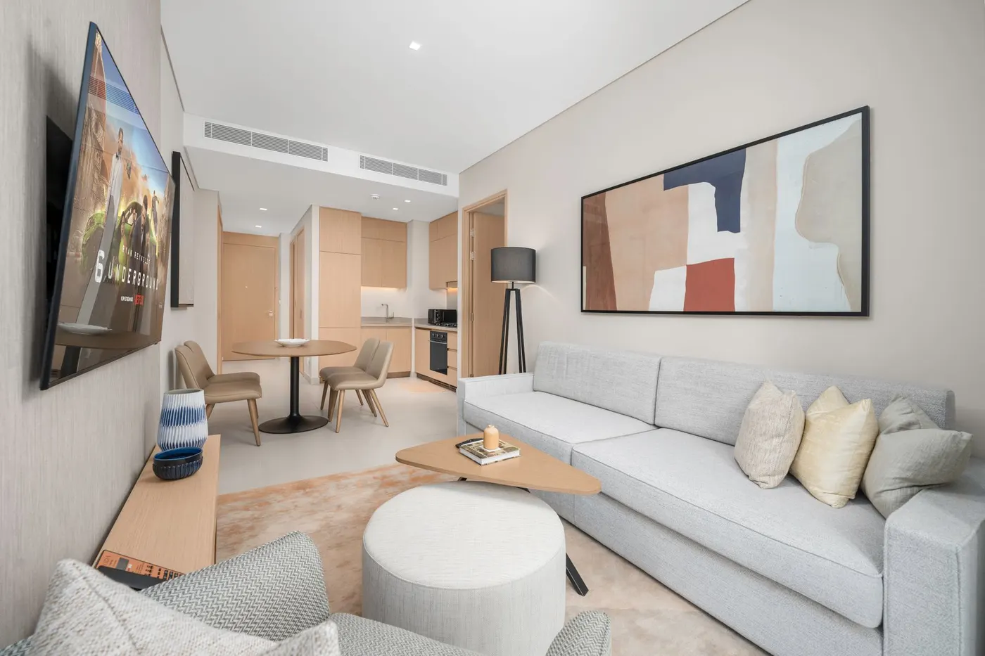 Modern living room with a light sofa and open kitchen