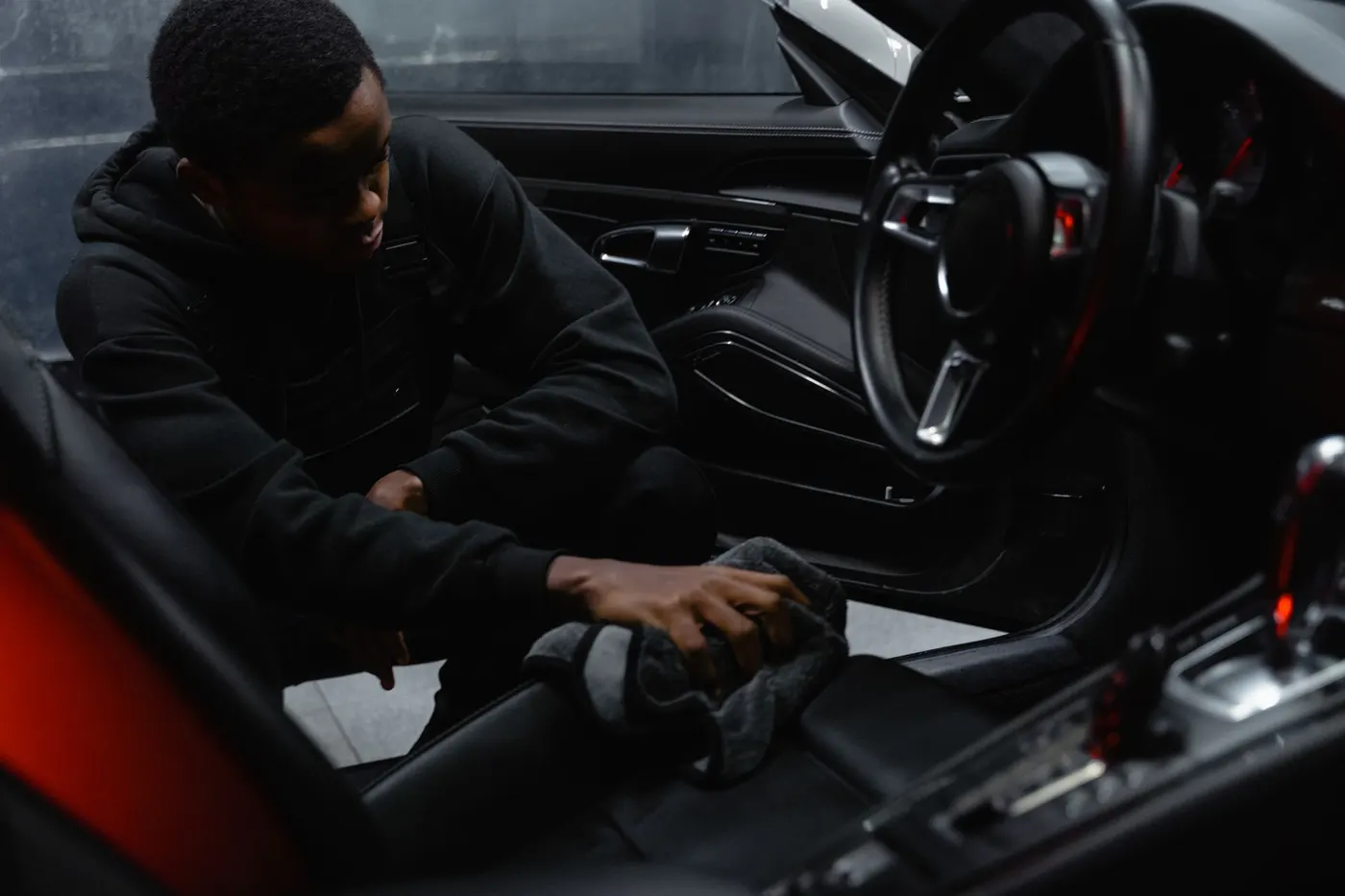Detailer cleaning the interior and seats of a car