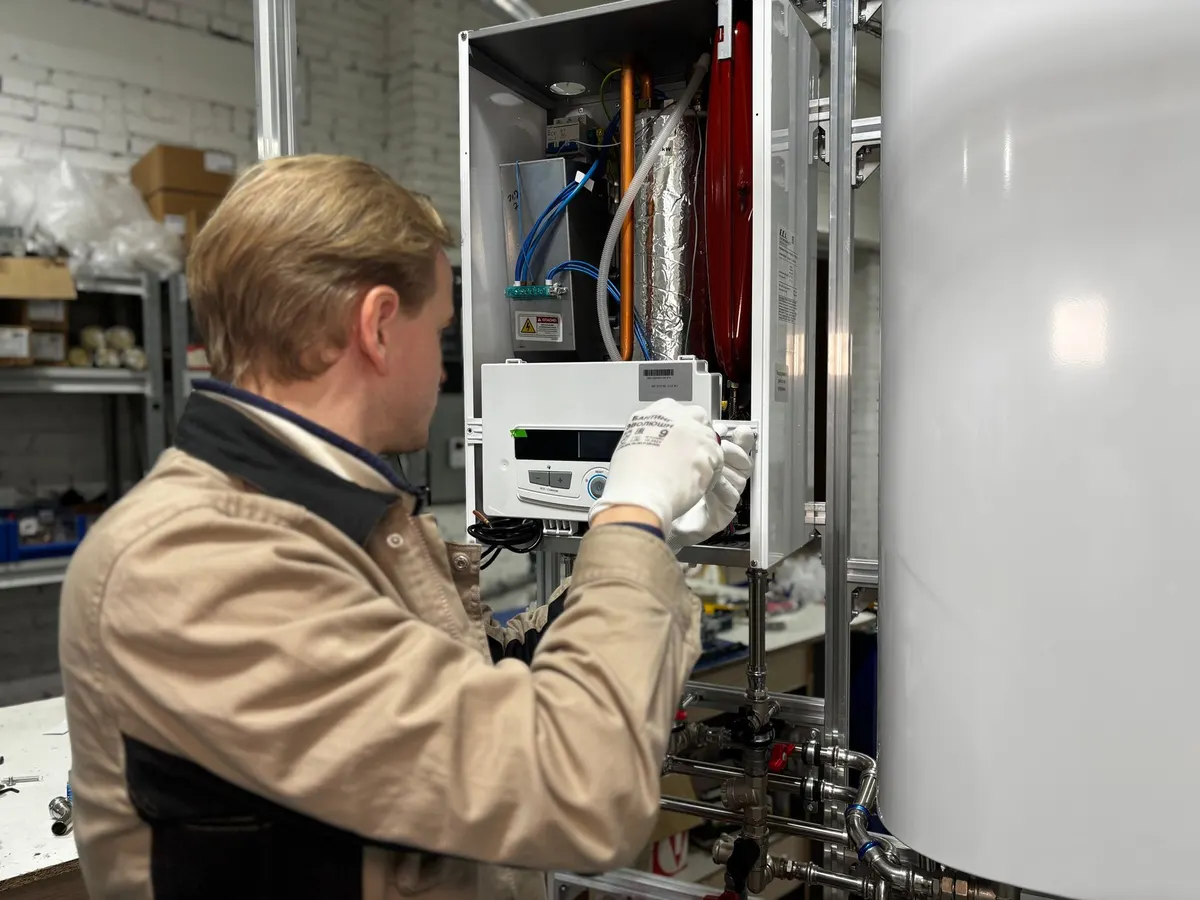Technician servicing a wall-mounted heating unit