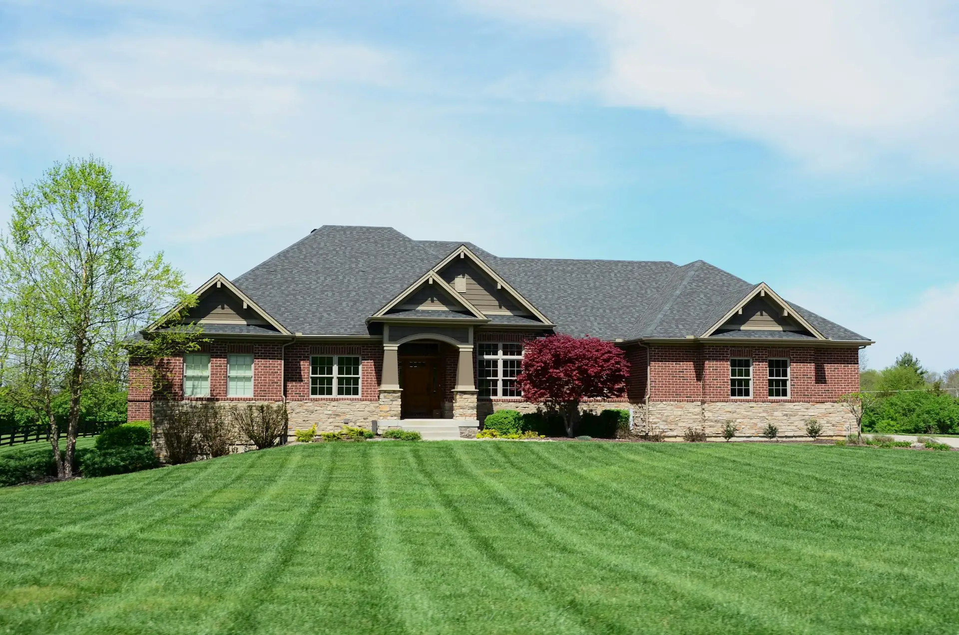 Striped lawn in front of a brick home
