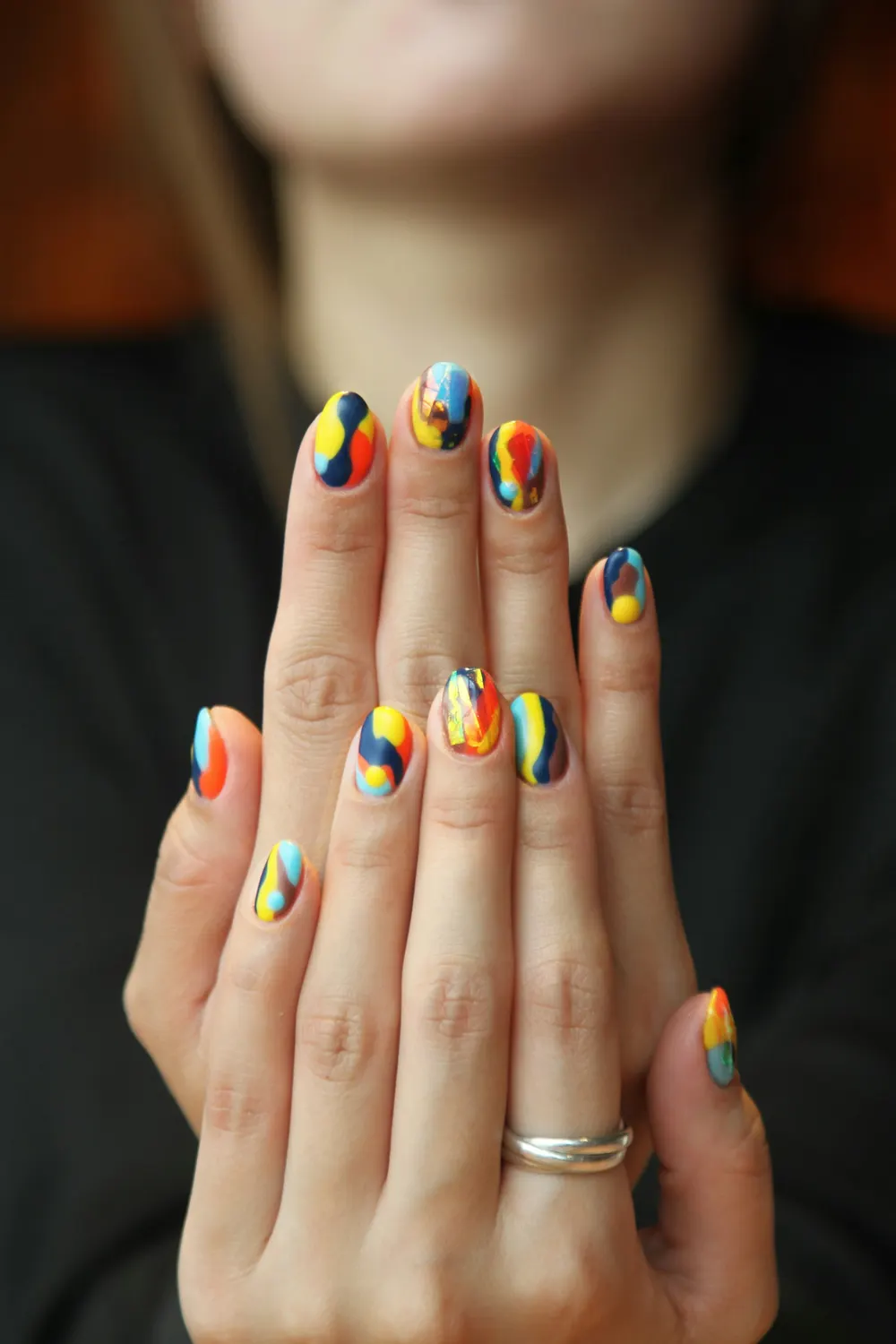 Hands showing colorful abstract nail art