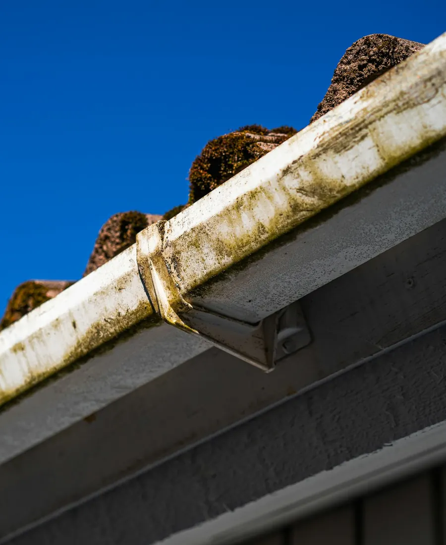 Roof edge and gutter against a deep blue sky