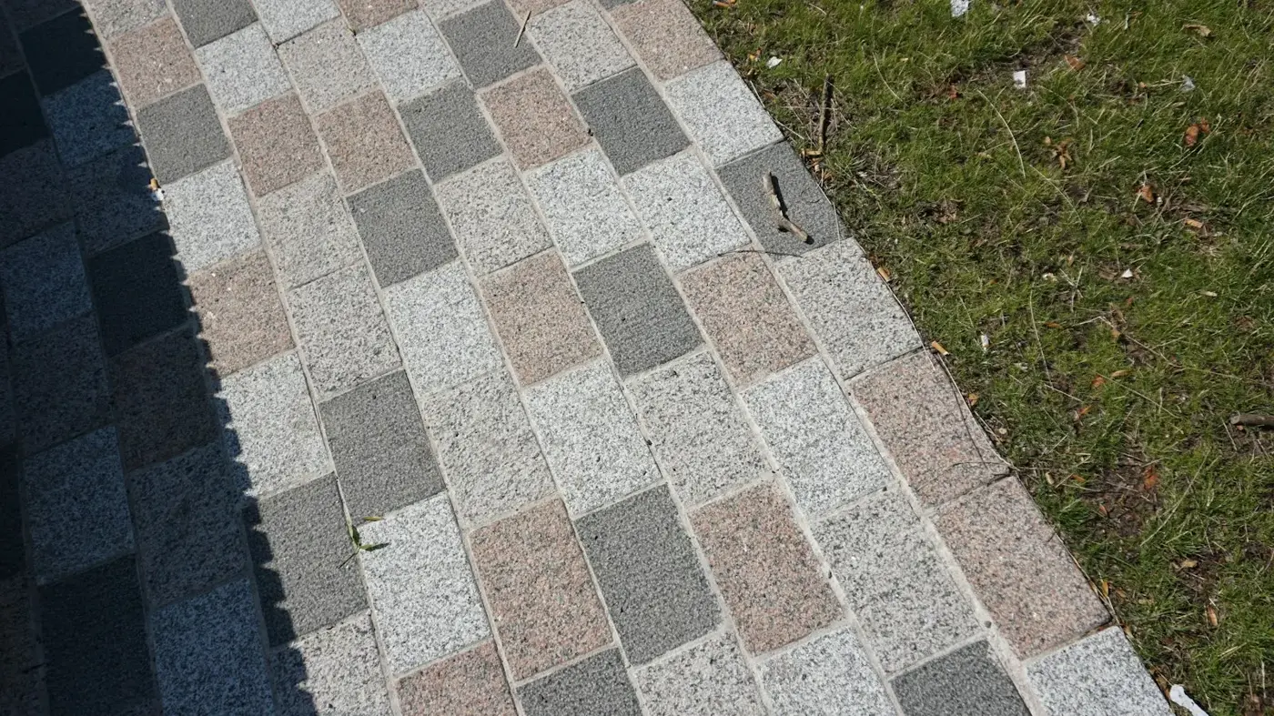 Clean asphalt shingle roof edge meeting a green lawn