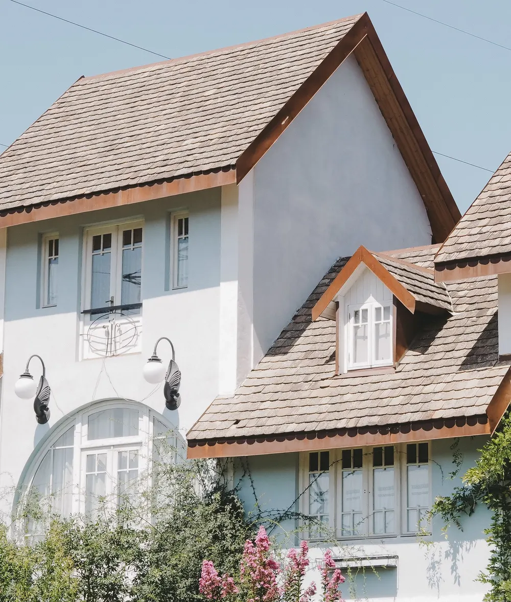Two-story home with a steep shingle roof and dormer