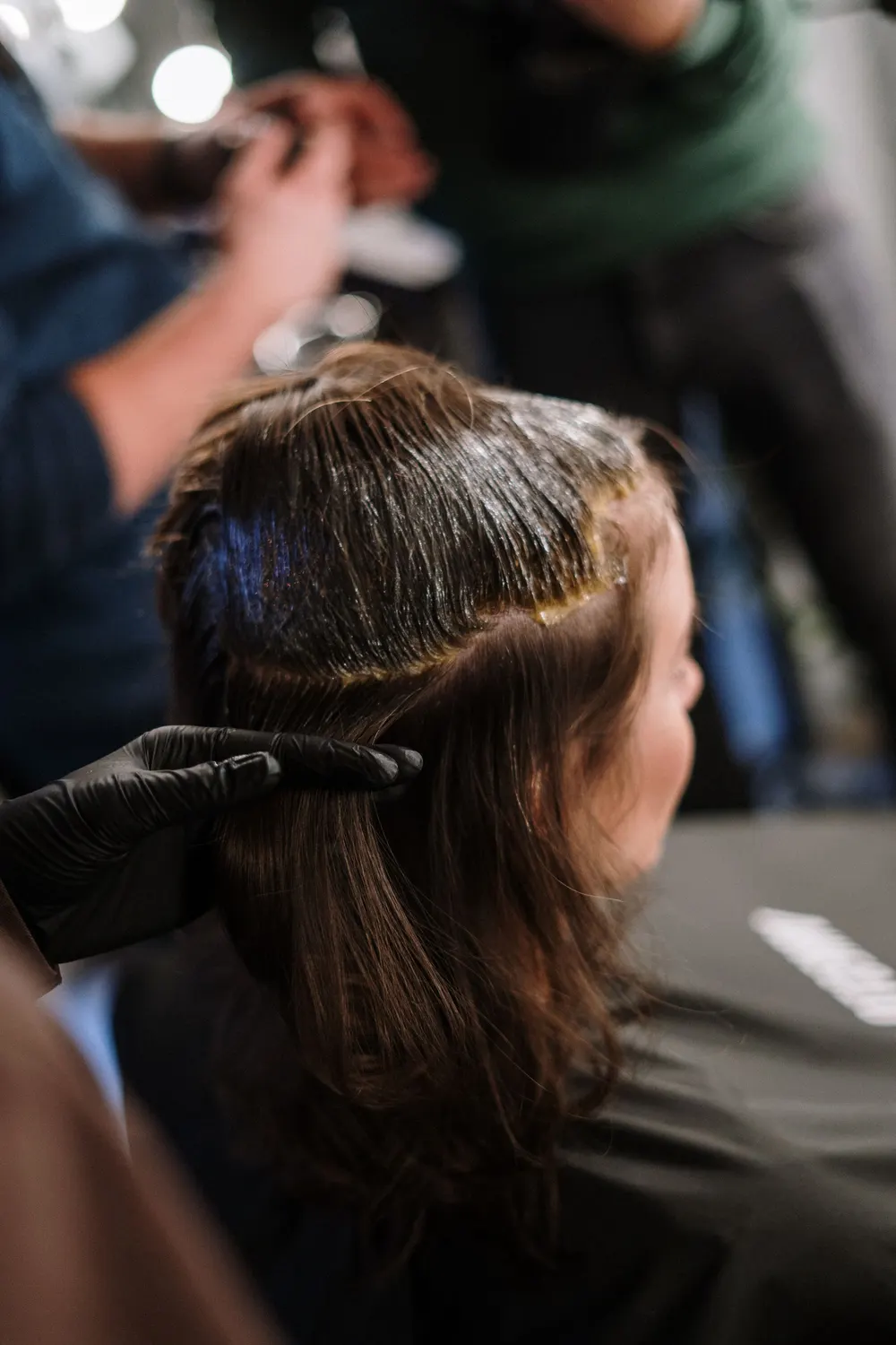 Colorist applying hair color to a client's sectioned hair