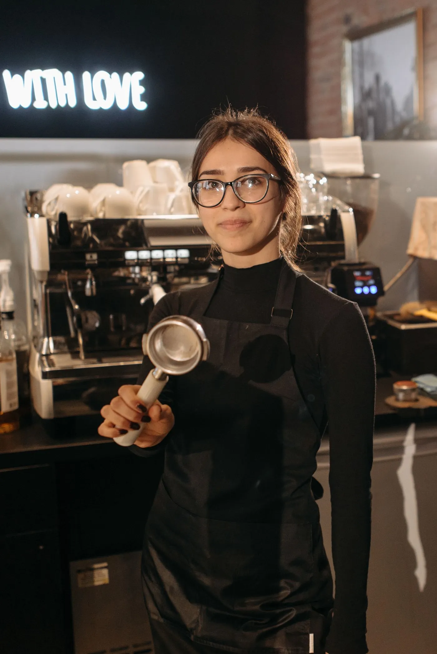 Coffee shop owner holding a portafilter behind the counter